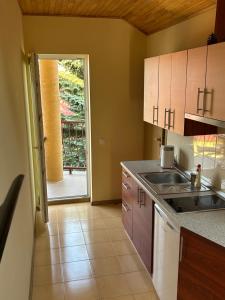 a kitchen with a sink and a door to a patio at Svečių namai Vilma in Šventoji