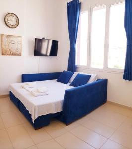 a blue couch in a room with a bed at Bindi Studio Apartment in Draç +30 photos