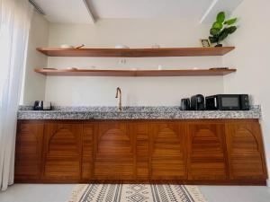 - une cuisine avec des placards en bois et un évier dans l'établissement Medina Baye Résidence Boutique Hôtel, à Kaolack