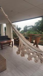 a hammock in a room with a balcony at BEACHFRONT APPARTMENT in Kribi