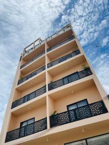 wysoki budynek z balkonami i niebieskim niebem w obiekcie Medina Baye Résidence Boutique Hôtel w mieście Kaolack