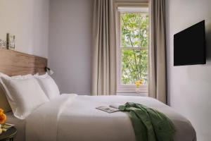 sypialnia z białym łóżkiem i oknem w obiekcie Sonder The Gilbert w Londynie