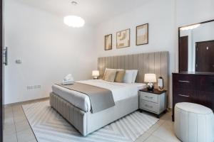 a bedroom with a large bed and a dresser at Stunning 1-Bedroom Apartment with full Burj Khalifa View - 5-min walk to Dubai Mall in Dubai +22 photos