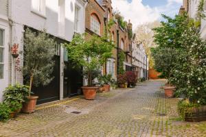 an empty street with potted plants and buildings at Sonder The Gilbert in London