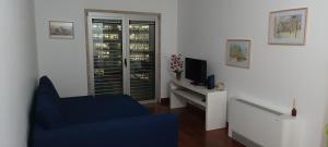 a living room with a blue chair and a television at Global Guest PN in Lisbon