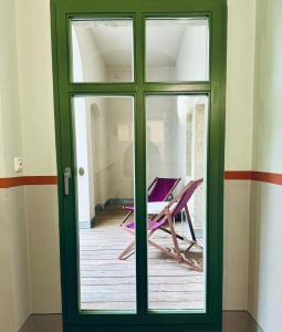 una puerta verde con mesa y sillas en una habitación en Hip & Minimalist - Stadt Apartments am Malerweg, en Pirna