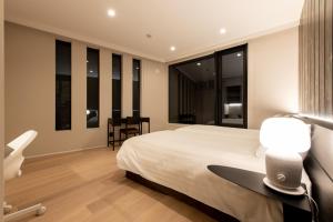 um quarto com uma cama, uma secretária e janelas em Yuki Sugi at Intuition em Niseko
