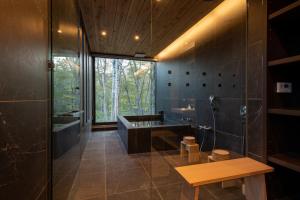 a bathroom with a shower and a sink and a tub at Yuki Sugi at Intuition in Kutchan