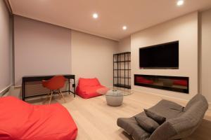 Il comprend un salon doté d'un mobilier rouge et d'une télévision à écran plat. dans l'établissement Yuki Sugi at Intuition, à Niseko