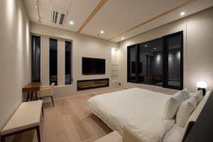 a bedroom with a bed and a desk and a tv at Yuki Sugi at Intuition in Kutchan