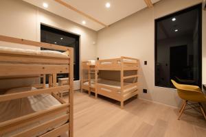 a room with two bunk beds and a chair at Yuki Sugi at Intuition in Kutchan +14 photos