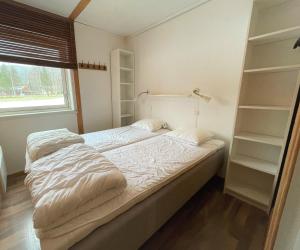 a bedroom with a bed and shelves and a window at Lassiebyn 10 in Branäs