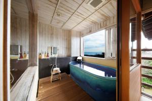 un bagno con ampia vasca e finestra di 伊豆高原の隠れ宿Syuhari守破離 a Ito