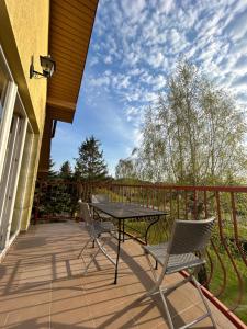 a patio with a table and chairs on a balcony at Svečių namai Vilma in Šventoji
