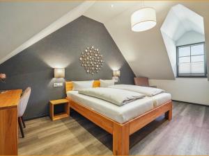 a bedroom with a large bed in a attic at Hotel Landlust St. Martin in Sankt Martin