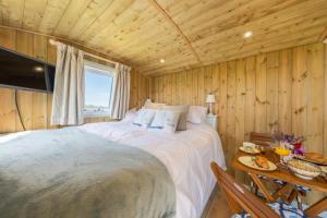 a bedroom with a large bed in a wooden room at Saltmarsh Hut in Stiffkey