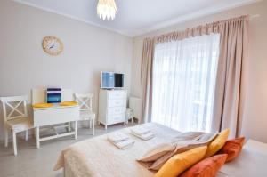 a white bedroom with a bed and a window at Apartamenty na Wyspie - Trzy Korony - Studio z parkingiem in Świnoujście