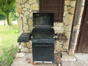a grill sitting in front of a stone building at Log cabin in Belgrade