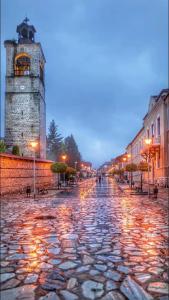 a cobblestone street with a clock tower in a city at Belvedere Holiday Club Private Apartment in Bansko