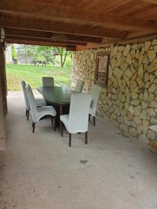 a table and chairs sitting around a stone wall at Log cabin in Belgrade