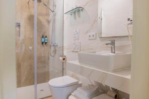 a bathroom with a toilet and a sink and a shower at Hotel Avenida in Póvoa de Varzim