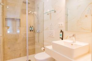 a white bathroom with a sink and a shower at Hotel Avenida in Póvoa de Varzim