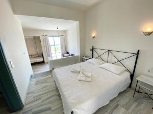 a bedroom with a white bed with two white towels on it at Hotel Plakures in Falasarna