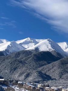uma vista para uma montanha com montanhas cobertas de neve em Belvedere Holiday Club Private Apartment em Bansko