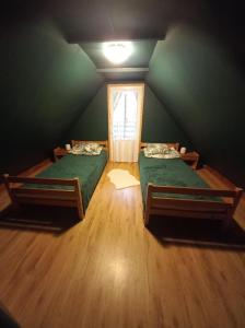 two beds in a room with a green wall at U Dziadka 