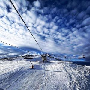 una pista de esquí cubierta de nieve con remonte en Belvedere Holiday Club Private Apartment, en Bansko
