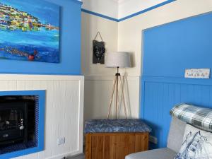 ein Wohnzimmer mit blauen Wänden und einem Kamin in der Unterkunft Seaitall in Torquay