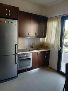 a kitchen with wooden cabinets and a stainless steel refrigerator at DRYADES in Agios Nikolaos