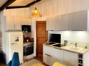 a kitchen with a white refrigerator and a sink at Le Chaîne - Vieux port centre in La Rochelle