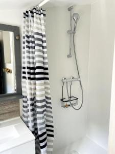 a bathroom with a black and white shower curtain at Le Chaîne - Vieux port centre in La Rochelle