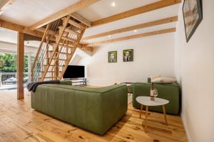 ein Wohnzimmer mit 2 grünen Sofas und einem Tisch in der Unterkunft Suite mit Dachterrasse in Dedelstorf