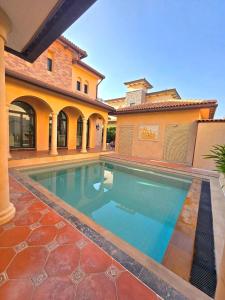 a swimming pool in front of a house at Nusa chivani pool villa najomtien with 4 bedrooms ณุศา ชิวานี พลูวิลล่า 4 ห้องนอน นาจอมเทียน in Na Jomtien