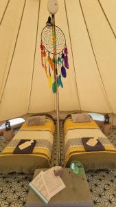 2 lits jumeaux dans une tente avec une lampe dans l'établissement Calla Retreat, à Vezenkovo