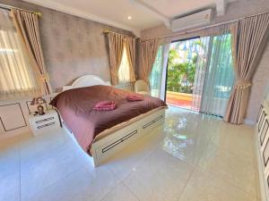 a bedroom with a bed and a large window at Nusa chivani pool villa najomtien with 4 bedrooms ณุศา ชิวานี พลูวิลล่า 4 ห้องนอน นาจอมเทียน in Na Jomtien +69 photos