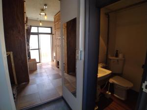 a bathroom with a toilet and a sink at Toyako Guest House Ponkotan in Lake Toya