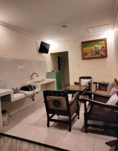 uma sala de estar com 2 cadeiras, uma mesa e um lavatório em Sulfat indah Home Stay Syariah em Ngadipuro