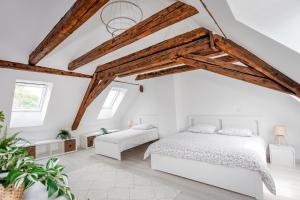 a bedroom with white walls and wooden beams at Le Grenier du Photographe in Kaysersberg