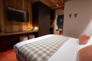 a bedroom with a bed and a flat screen tv at Hôtel Névé in Morzine