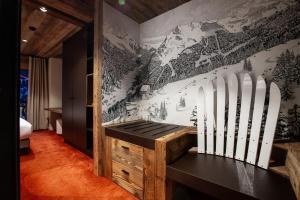 a bedroom with a wall with skis on it at Hôtel Névé in Morzine