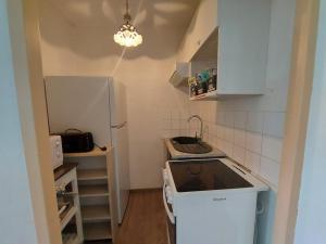 uma pequena cozinha com um frigorífico e um lavatório em La goelette à la plage em Saint-Hilaire-de-Riez