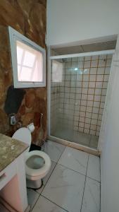 a bathroom with a toilet and a glass shower at Los primos in Búzios