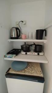 a kitchen with two pots and pans on shelves at Los primos in Búzios