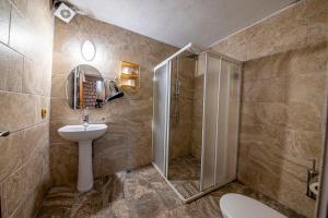 uma casa de banho com um chuveiro, um lavatório e um WC. em Asyada Suites Hotel em Nevşehir