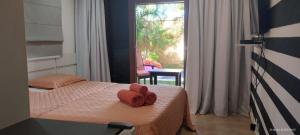 Un dormitorio con una cama con toallas rojas. en Casa incrivel piscina privada e jacuzzi Villa Deluxe Pipa Spa Beleza Resort, en Pipa