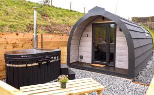 a igloo house with a hot tub and a bench at Primrose Glamping Pods in Ingleton 