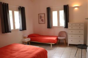 a bedroom with two beds and a dresser and two windows at Agréable villa vue mer avec piscine Sagone in Sagone +16 photos